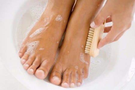 Женщина моет ноги